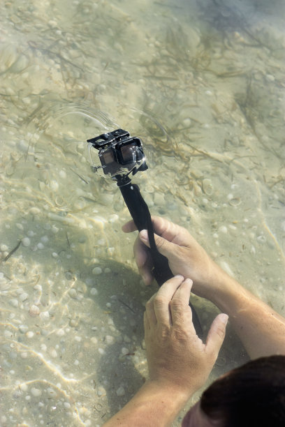 男人的手在水下拿着运动相机图片下载