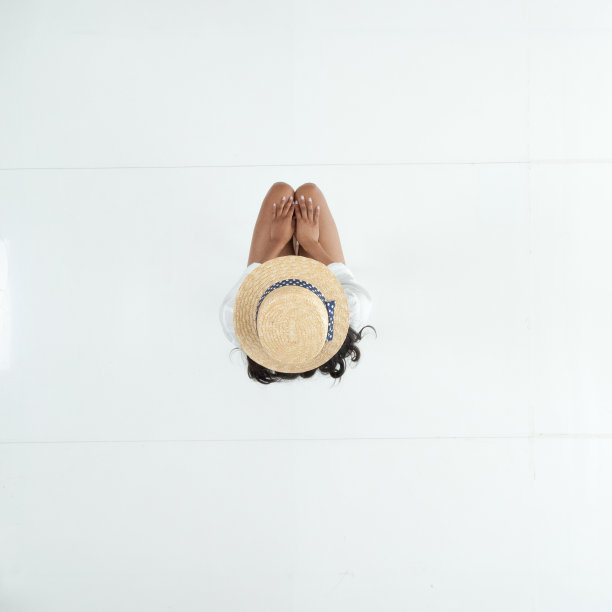 拉丁美洲和西班牙裔女性坐在地板前的白色背景穿着纽扣衬衫图片下载