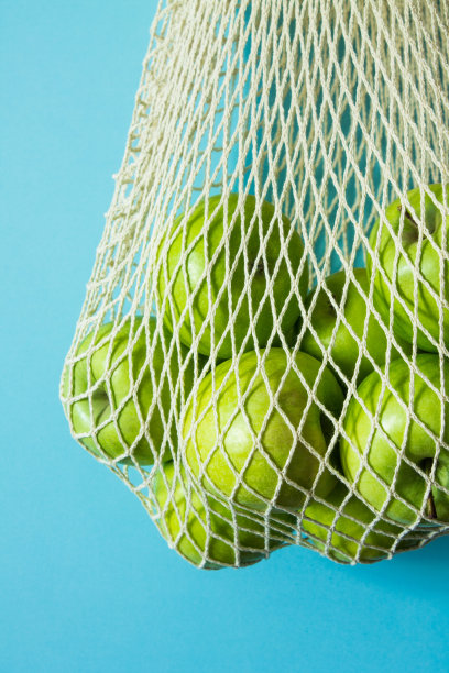 可重复使用的网袋与绿色的苹果特写图片下载