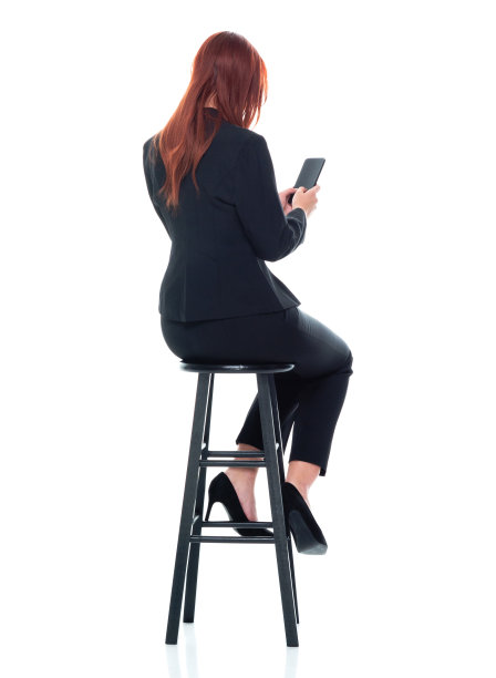 白人女性商务人员在白色背景前休息，穿着商务服装，使用智能手机图片下载