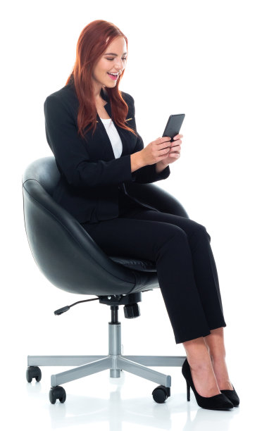 白人女性商务人员在白色背景前休息，穿着商务服装，使用智能手机图片下载