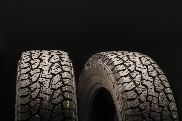 两个越野车轮有强大的踏面，泥花纹与板条，切口和格子在黑色的背景。为男人的娱乐美丽的车轮。在顶部留出文字空间。copyspace。图片下载