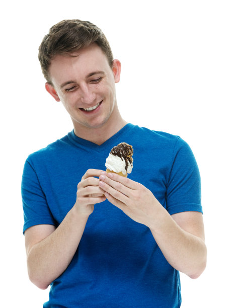 白人年轻男性穿着t恤拿着冰淇淋站在白色背景前图片下载