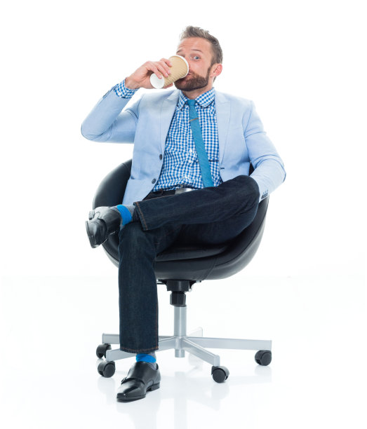 白人年轻男性商人坐在白色背景穿着衬衫和拿着咖啡杯图片下载