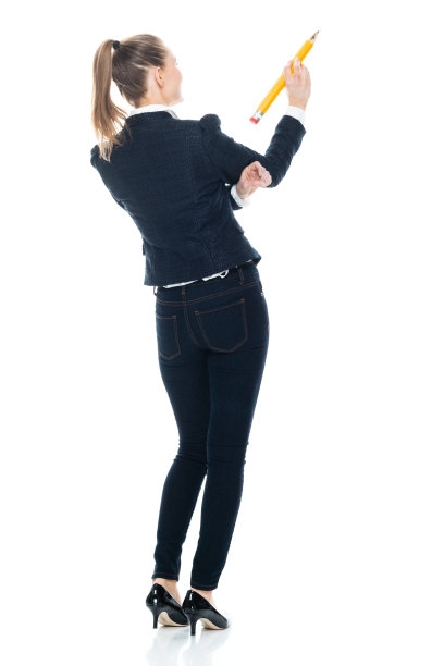 白人女学生站在白色背景前穿着漂亮的便服，用铅笔图片下载