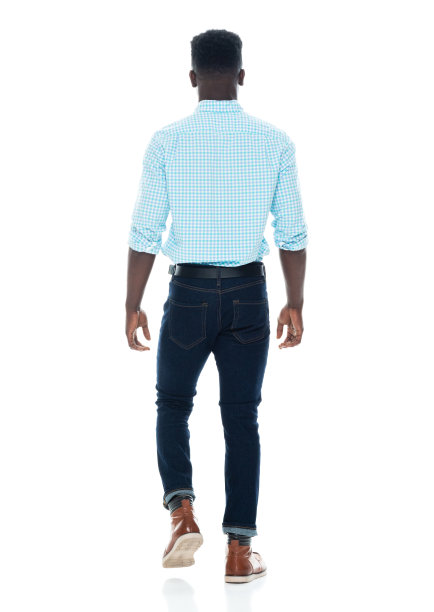 非裔美国男性穿着牛仔裤走在白色背景前图片下载