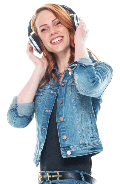 白人年轻女性穿着裤子戴着耳机站在白色背景前图片下载