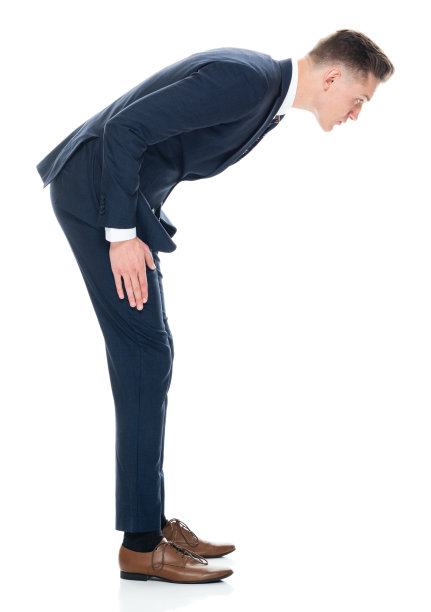 白人年轻男性商人在白色背景下鞠躬，穿着商务服装图片下载