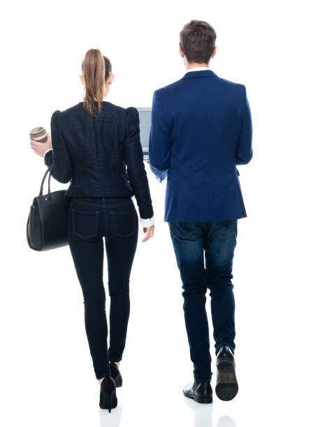 白人男性商人穿着夹克，拿着钱包，使用笔记本电脑走在白色背景前图片下载