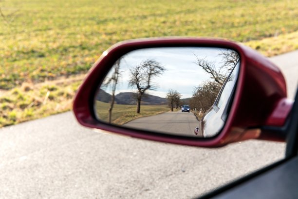 汽车镜子里的风景。侧车镜上的景观图像，概念旅游。看着车窗外的后视镜图片下载