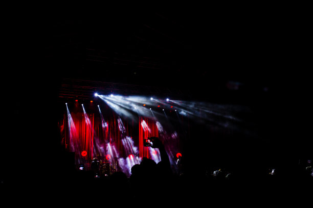 许多人在欣赏夜晚的表演，一大群不认识的人举起手和手机在音乐会上跳舞。夜生活图片下载