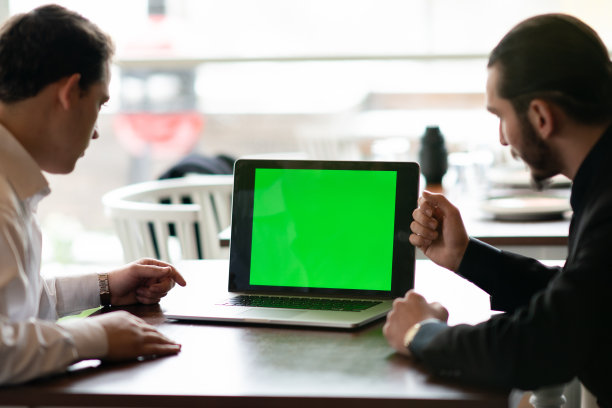 年轻的商人在会议上使用绿色屏幕的笔记本电脑图片下载