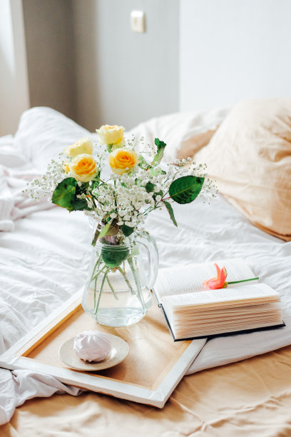 在床上慵懒的早晨。两人份的花和茶。周末轻松阅读。图片下载