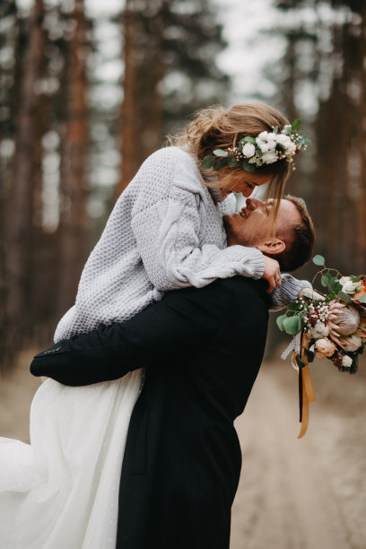 新婚夫妇在松树林中的小路拥抱。图片下载