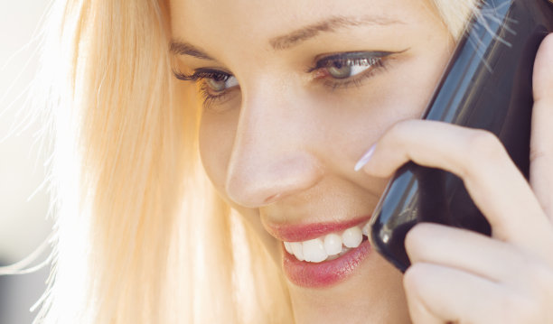 使用智能手机交谈的金发美女图片下载