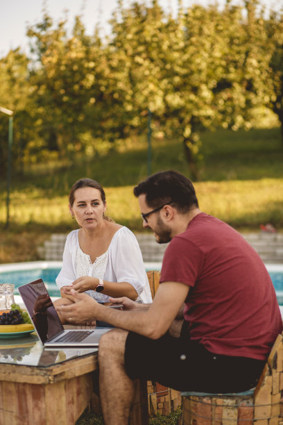 一对成熟的夫妇在泳池边放松图片下载
