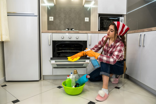戴橡胶手套和消毒剂的女人在厨房洗地板图片下载