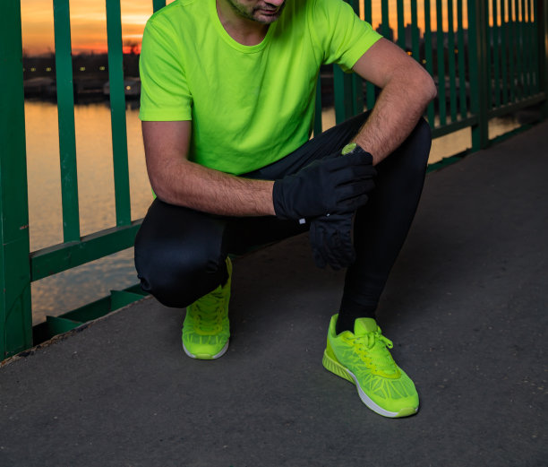 在日落/日出时，一个运动员在河上的一座桥上停下来。图片下载