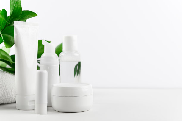 一套有机化妆品的脸部和身体护理在白色的背景。奶油，洗发水，乳液和口红在一个明亮的背景组成。皮肤、嘴唇和头发护理。空间模型,复制图片下载