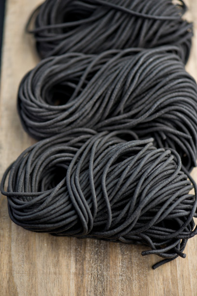 墨水鱿鱼面食。新鲜的自制，传统的经典地中海菜肴，芳香的黑鱿鱼墨意大利面。新鲜的鸡蛋意面染成丝滑的黑色。图片下载