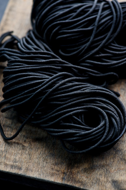 墨水鱿鱼面食。新鲜的自制，传统的经典地中海菜肴，芳香的黑鱿鱼墨意大利面。新鲜的鸡蛋意面染成丝滑的黑色。图片下载