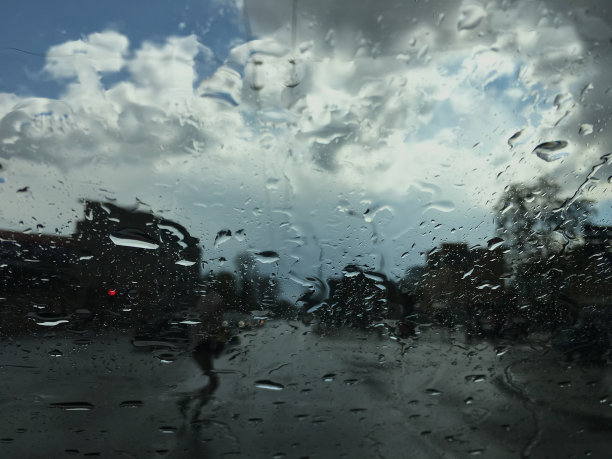水滴在车窗玻璃上，雨在城市里。图片下载