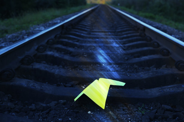 躺在铁轨上的黄色手工纸飞机。自由概念照片。旅行生活方式的激励。铁路运输行业。图片下载