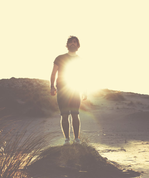 一个留着胡子的年轻人站在背光下图片下载