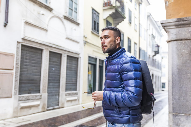 在意大利街头的人行道上等待交通工具的男性旅行者-库存照片图片下载
