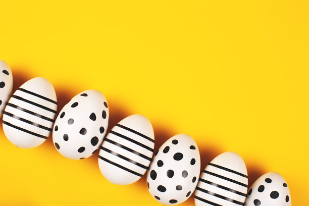 复活节组成。漂亮的鸡蛋在明亮的黄色背景。图片下载
