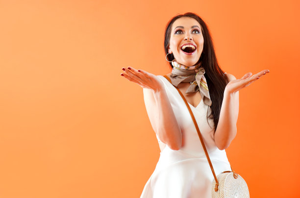 美丽的女人感到喜悦和惊喜，举手欢呼，表达情感图片下载