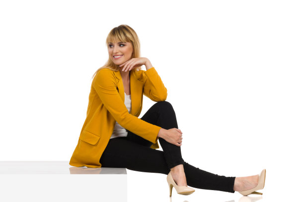 一位美丽的年轻女子正坐在台阶上，从肩膀往后看图片下载