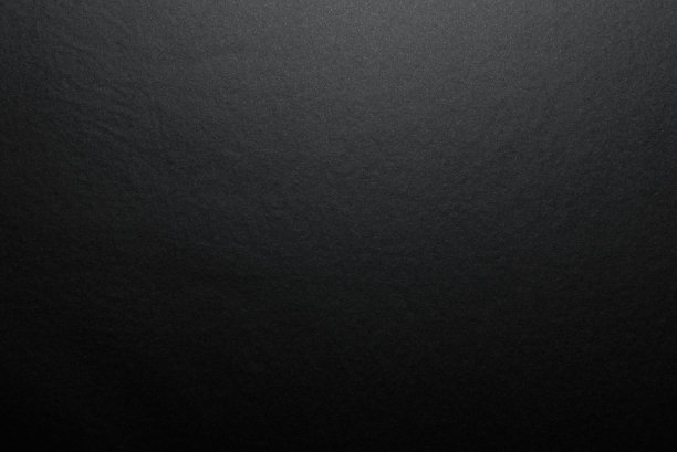 黑色背景由真正的黑色纸和亚光纤维结构，由柔和的光从上面照亮。图片下载