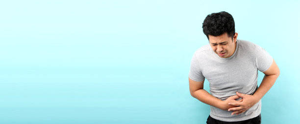 生病的亚洲男人肚子疼，在蓝色背景的演播室里，有复制空间。图片下载