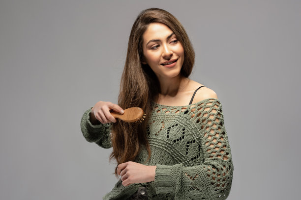 美丽的黑发女人梳头的肖像图片下载