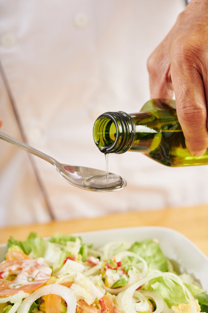 男人在沙拉中加入油图片下载