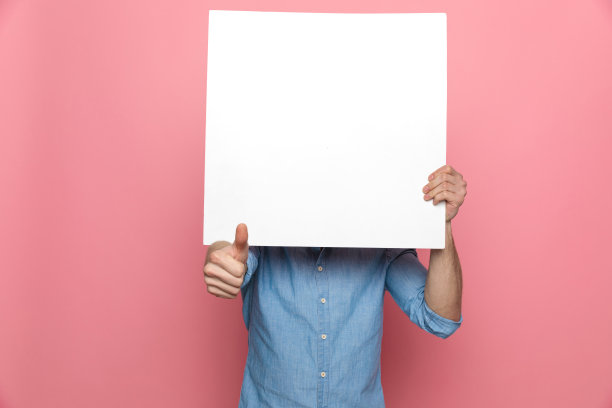 年轻休闲男子用空白板遮住脸图片下载