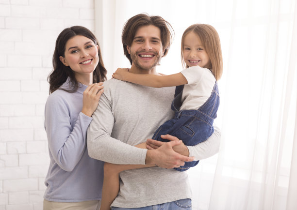 快乐的父亲和母亲摆姿势与他们的小女儿在手上图片下载