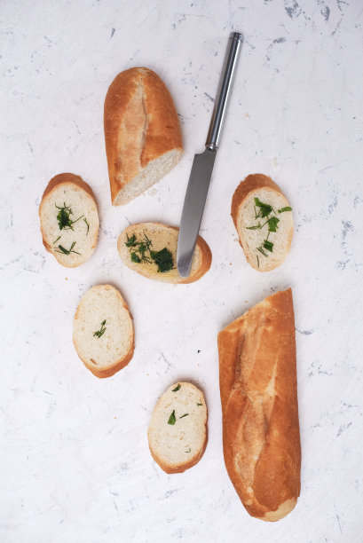 这是一幅静物画，画上是法国新鲜的长棍面包，配上木头切菜板和小麦，浅dof图片下载