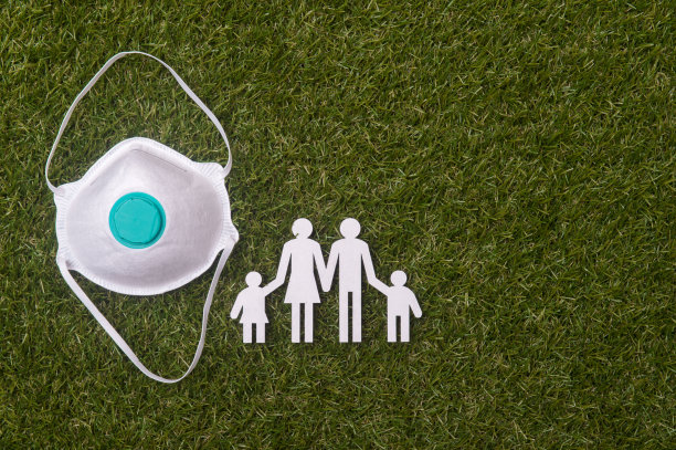 绿色草地背景上的纸板家庭人物和面具，新型冠状病毒概念图片下载