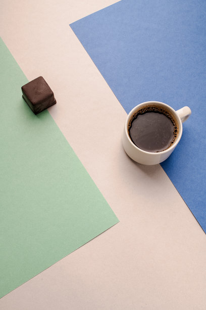 一杯白杯子里的咖啡，黑巧克力在彩色背景上图片下载