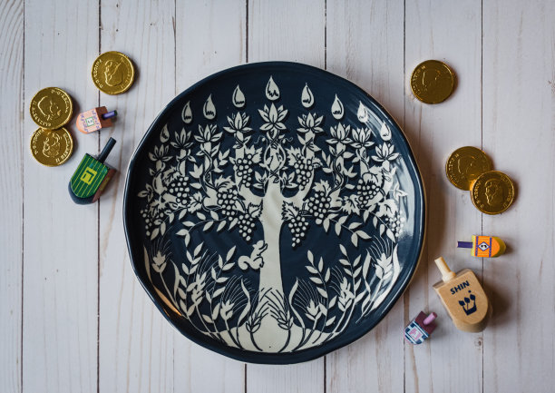 光明节的盘子，陀螺和巧克力硬币在白色的木头上。图片下载