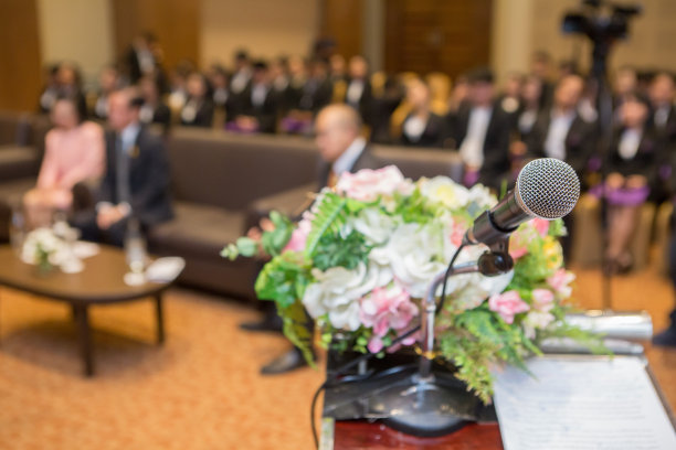 讲台上的麦克风和会议室里的人图片下载