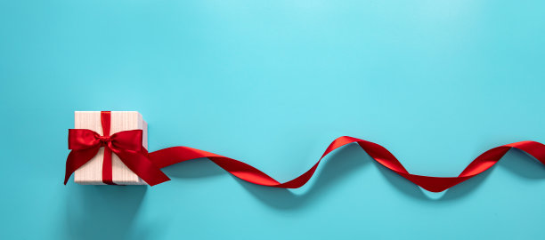 蓝色背景上的红色蝴蝶结礼盒。快乐的父亲或母亲或妇女节庆祝概念图片下载