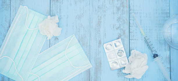 蓝色木质背景的医用口罩。病毒防护概念。新冠肺炎疫情蔓延。戴上防护口罩。图片下载