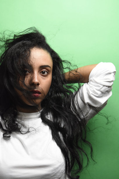 有着一头黑发的中东年轻女子。室内照片的奇妙女性模特在绿色的背景。图片下载