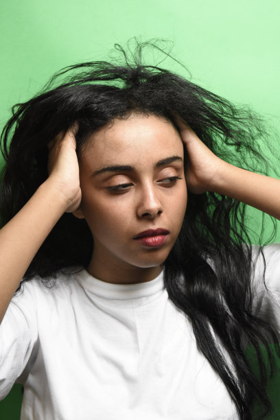 有着一头黑发的中东年轻女子。室内照片的奇妙女性模特在绿色的背景。图片下载