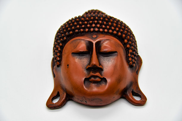 浅色背景上的棕色佛像头图片下载