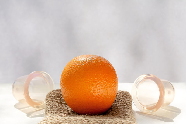 橙子躺在天然纤维制成的网状毛巾上，旁边是真空银行。图片下载