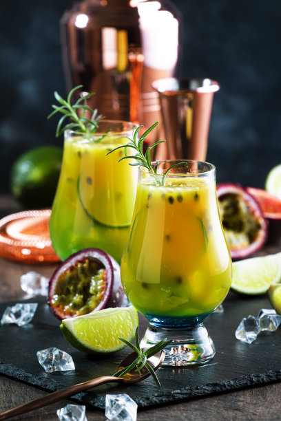 百香果鸡尾酒与迷迭香和冰块在玻璃，酒吧工具，拷贝空间图片下载